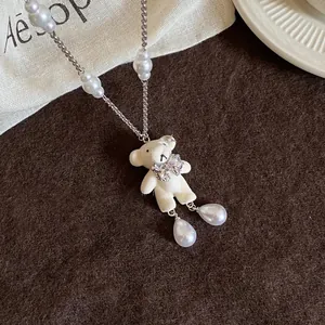Détail du collier ours en peluche avec perles et nœud scintillant