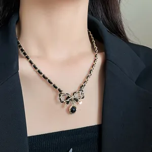 Vue détaillée du collier à nœud rétro avec chaîne dorée entrelacée de cuir noir