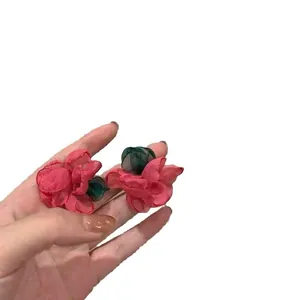 Handmade pink mesh flower stud earrings with green leaves, forest style design.