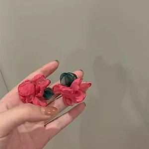 Close-up detail view of elegant handmade mesh flower earrings in vibrant pink and green colors