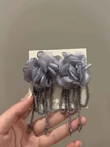 Detailed view of handmade mesh flower stud earrings featuring elegant grey bead tassels