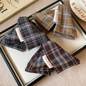 Close-up of handmade fabric plaid triangle hair clips in three vintage patterns