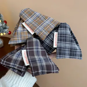 Detail showing textured plaid fabric and 'Handmade' label on triangle hair claw clips
