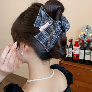 Macro view of elegant plaid fabric hair claw clip with Handmade label on bun hair style