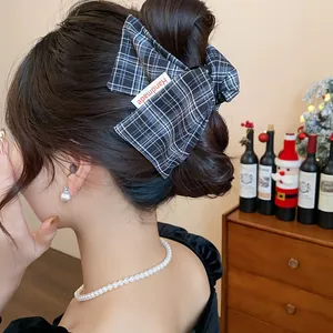 Detailed view of a plaid fabric hair claw clip styled in an elegant updo hairstyle