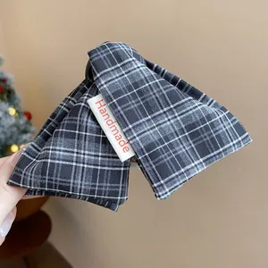 Detailed view of gray plaid fabric triangle hair claw clip with white Handmade label
