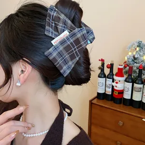 Elegant brown plaid fabric hair claw clip for bun hairstyles worn by an Asian model