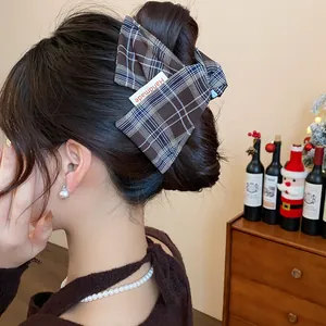 Detail of brown plaid fabric hair claw clip on an elegant updo hairstyle.