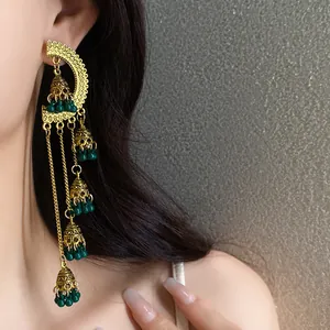 Close-up of vintage court style tassel earrings with green beads and gold bells