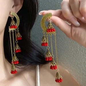 Exquisite detail of vintage palace style tassel earrings with red beads and golden bells