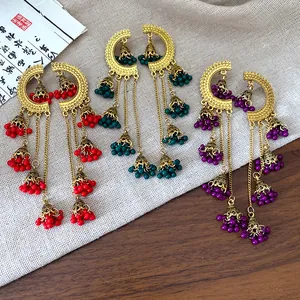 Close-up view of vintage ethnic bell tassel earrings in red teal and purple variants