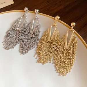 Close-up detail of elegant long tassel earrings in both gold and silver finishes