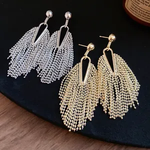 Close-up detail of vintage-style irregular metallic tassel stud earrings in gold and silver