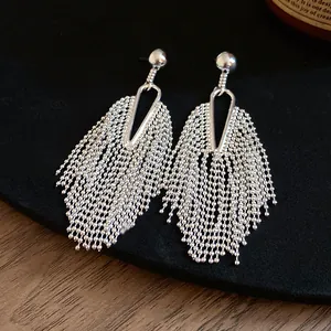 Close-up view of silver-tone tassel earrings featuring delicate beaded chain fringe details.