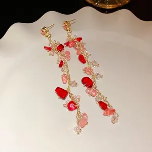 Long tassel earrings featuring pink and red crushed stones with silver needle posts.