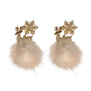 Elegant gold-tone Christmas reindeer earrings with snowflake and soft white fluffy pom-poms