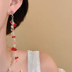 Detail view of elegant silver needle earrings with pink crushed stone long tassels
