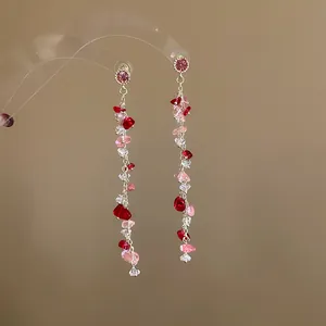 Elegant detail of silver needle tassel earrings with pink crushed stones and crystals.