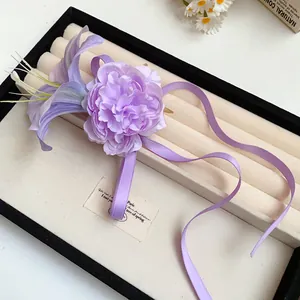 Primo piano di un'elegante molletta per capelli a fiore in tessuto viola con nastri.