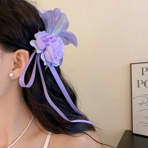 Primo piano di un elegante fermaglio per capelli a fiore in tessuto viola con nastri
