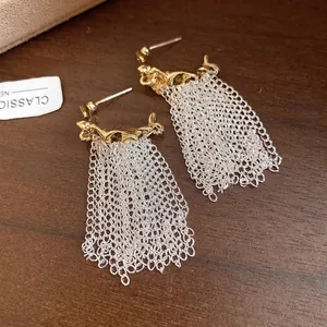Elegant gold pleated C-shaped earrings with long silver chain tassels