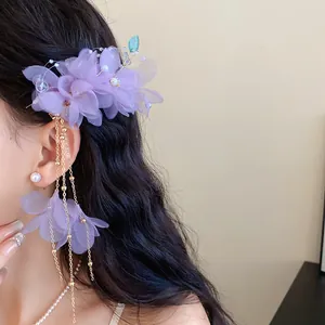 Dettaglio dell'elegante fermaglio per capelli con fiori viola e nappe di perle