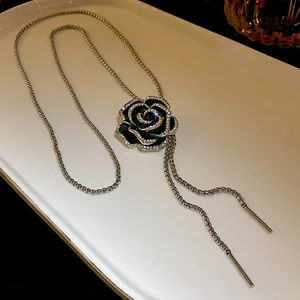 Vista dettagliata di una collana con ciondolo a camelia in smalto nero e accenti di zircone