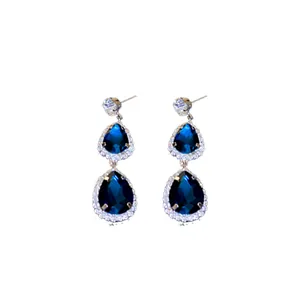 Elegant silver needle drop earrings with blue tear-shaped gems and halo rhinestones