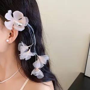 Dettaglio ravvicinato di un'elegante molletta a fiore in rete rosa su capelli mossi