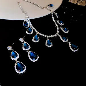 Close-up detail of a vintage luxury jewelry set featuring blue teardrop stones and rhinestones.