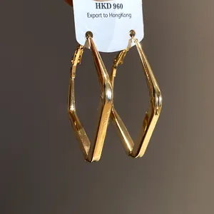 Dettaglio degli orecchini a cerchio geometrici a rombo dorati su cartellino