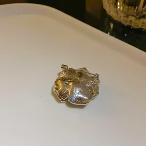 Vista dettagliata del retro di una spilla a camelia argento con spilla di sicura