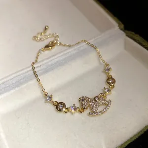 Close-up of 14k gold plated bracelet with sparkling zircon rocking horse pendant