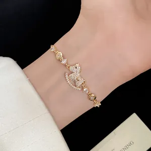 Detailed close-up of a 14k gold plated bracelet featuring a zircon rocking horse pendant.