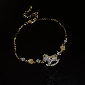 Close-up of a 14k gold plated rocking horse bracelet with sparkling zircon stones.