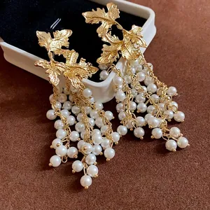 Orecchini a foglia d'acero dorata con eleganti nappe di perle lunghe e perni in argento