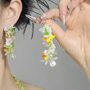Detailed view of forest-style shell flower earrings with colorful beaded tassels
