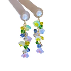 Elegant forest-themed floral tassel earrings with colorful crystals and faux pearls on white.