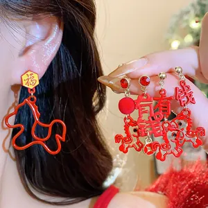 Close-up of festive red earrings featuring zodiac horse and Chinese fortune characters