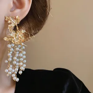 Eleganti orecchini a foglia d'acero dorata con nappe di perle bianche