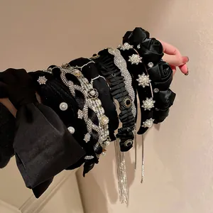 Dettaglio di cerchietti barocchi in velluto nero con perle, pizzo e decorazioni a fiocco.