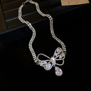 Detail view of a sparkling zircon bow-knot necklace featuring a large teardrop pendant.