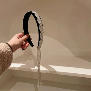 Elegante fascia in velluto nero con motivo ondulato di strass scintillanti e nappe lunghe.
