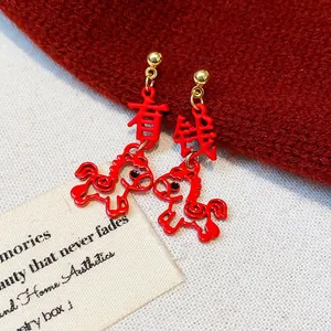 Detail showing red horse-shaped earrings with 'Wealth' Chinese character design