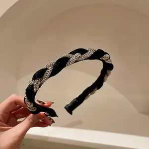Dettaglio di un cerchietto vintage in velluto nero con strass di cristallo luccicanti