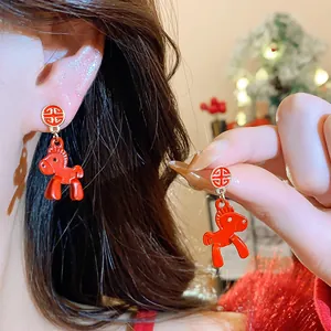 Detailed close-up of festive red horse drop earrings with lucky character stud