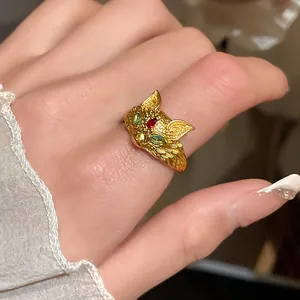 Macro view of vintage 24K gold plated fox ring with green and red zircon stones