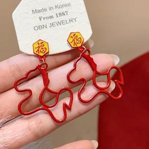Detailed shot of red horse-shaped outline earrings with festive Fu character design