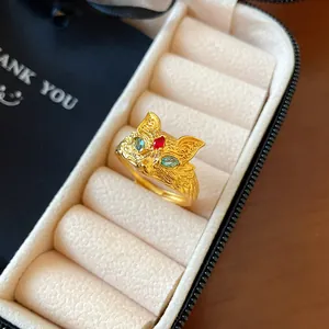 Detail shot of a golden fox ring with colorful zircon eyes in a jewelry box