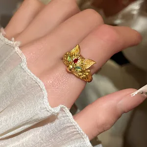 Macro view of a 24K gold plated fox head ring with green zircon eyes and vintage details.